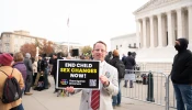 A demonstrator holds a sign opposing sex changes for minors at a rally on the steps of the United States Supreme Court on Dec. 4, 2024, as justices heard oral arguments in a challenge to a Tennessee law banning transgender surgeries for minors.