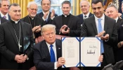 President Donald J. Trump is joined by legislators and Archbishop Bashar Warda of Erbil-Kurdistan, Iraq, left, as he signs H.R. 390, the Iraq and Syria Genocide Relief and Accountability Act of 2018 on Dec. 11, 2018, in the Oval Office of the White House.