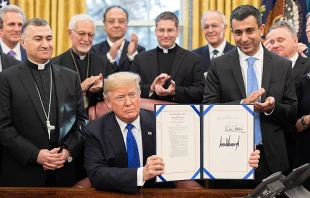 President Donald J. Trump is joined by legislators and Archbishop Bashar Warda of Erbil-Kurdistan, Iraq, left, as he signs H.R. 390, the Iraq and Syria Genocide Relief and Accountability Act of 2018 on Dec. 11, 2018, in the Oval Office of the White House. Credit: Official White House photo by Shealah Craighead; Public domain, via Wikimedia Commons