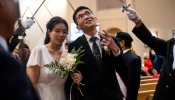 A groom flashes a peace sign at wedding-goers while processing out of St. Mary’s Church in Vancouver, British Columbia, Canada, after having his marriage sacramentally blessed at the Marriage Mass on Oct. 19, 2024.