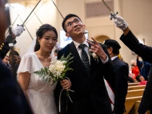 A groom flashes a peace sign at wedding-goers while processing out of St. Mary’s Church in Vancouver, British Columbia, Canada, after having his marriage sacramentally blessed at the Marriage Mass on Oct. 19, 2024.