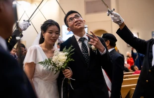 A groom flashes a peace sign at wedding-goers while processing out of St. Mary’s Church in Vancouver, British Columbia, Canada, after having his marriage sacramentally blessed at the Marriage Mass on Oct. 19, 2024. Credit: Nicholas Elbers/The B.C. Catholic