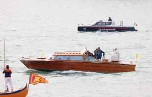 Pope Francis waves while traveling by boat in Venice, Italy, for a meeting with young people at the Basilica della Madonna della Salute on April 28, 2024. Earlier in the day he met with inmates at a women's prison. Credit: Daniel Ibañez/CNA