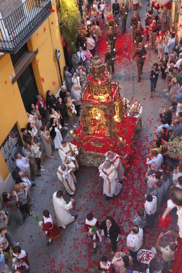 After a large group of vested priests processes down the street during the annual Corpus Christi procession in Valancia, Spain, followed by a group of sacristans creating a cloud of incense, Jesus arrives as flower petals rain down on the monstrance, thrown by the faithful gathered on their balconies and those lining the streets. June 2, 2024. Credit: Miriam Sancho