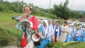 Women baptized by Prem Bhai climb to his memorial singing devotional songs during a 2018 observance of the Catholic missionary.