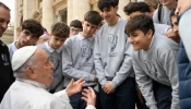 Pope Francis speaks with young men during a general audience.