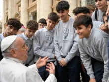 Pope Francis speaks with young men during a general audience.